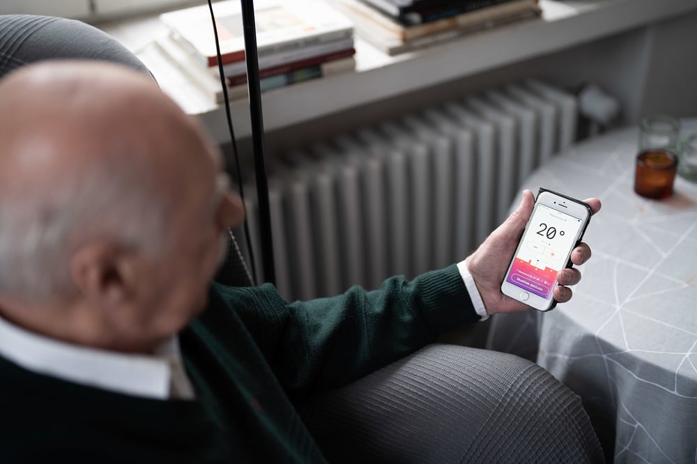 Mies katsoo Wattisen mobiilisovellusta kännykästä
